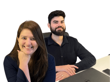 a man and woman sitting at a table with laptops
