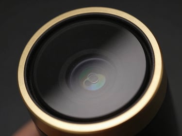 Macro close-up of MIREV aesthetic device, gold rim lighting, black mirror glass finish, 85mm