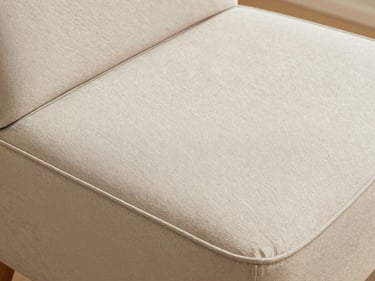 A clean, modern seat cushion with structured piping edges, soft diffused daylight highlighting the textile weave
