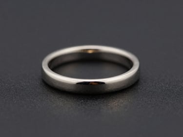 Macro shot of a minimalist platinum ring, clean lines, subtle metallic sheen, dark background.