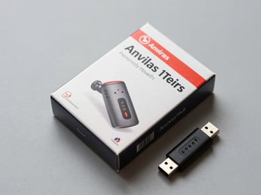 45-degree overhead shot of antivirus software box and USB dongle on a neutral gray surface, bright even lighting, catalog angle