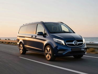 Luxury executive van driving on a wide coastal road near Oostende, dynamic angle, warm sunset lighting