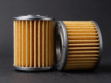 Flat-lay close-up of an oil filter cross-section and air filter element side by side on a dark matte background, studio lighting revealing fibrous filter media texture