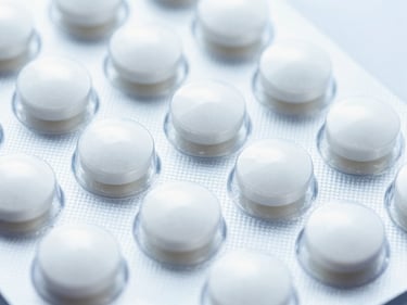 Close-up of pristine blister packs of white pharmaceutical tablets, bright high-key laboratory lighting, sharp macro focus, 35mm