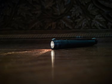 Lanterna EDC compacta de alta potência sobre fundo escuro para uso no Everyday Carry