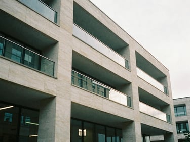Architectural detail of a modern UK office space, focusing on clean lines and natural light, soft British daylight, muted forest green and stone tones, 35mm film grain.