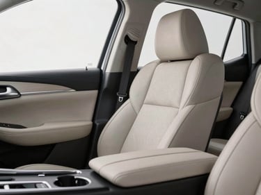 Close-up of a premium leather seat and clean center console of a Nissan vehicle, soft studio lighting highlighting the texture, professional automotive photography.