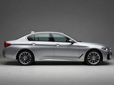 Front three-quarter driver-side profile of a silver BMW 5 Series sedan, studio strobe lighting, full vehicle visible, squared frame