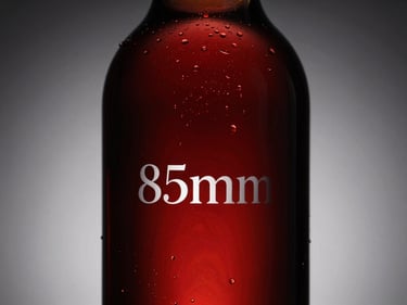 Low-key dramatic lighting on a 1.5L glass carafe bottle, elegant silhouette, minimal white typography on label.