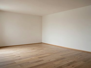 Wide environmental shot in natural daylight of an empty room after a house clearance: bare floors, clear walls, no objects remaining. Documentary framing, no people.