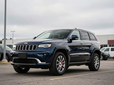 3/4-angle shot of a dark blue 2021 Jeep Grand Cherokee on a flat dealer lot, overcast daylight, wide environmental framing, no people