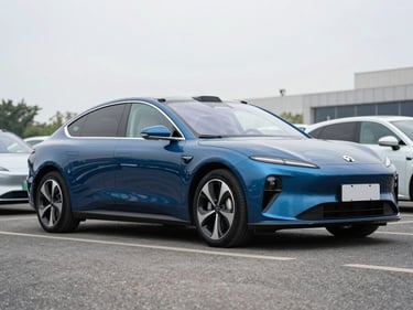 3/4-angle shot of a deep blue electric sedan parked on a dealer lot under bright overcast daylight, full vehicle visible, clean asphalt, no people