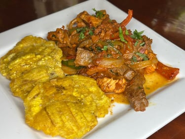 a plate of food with a mix of chicken beef and pork and tostones
