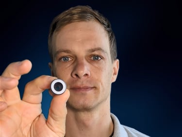 A close up of a male person holding an EQ Tool into the camera