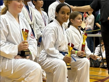 a group of people sitting on a bench with trophies