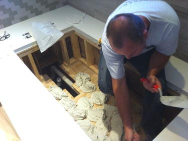 Remodeling project with tile installer leveling and setting floor for soaking bathtub