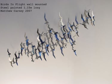 Steel sculpture of a flock of shearwaters in flight