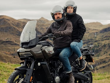 Para siedząca na motocyklu Harley-Davidson Pan America w modułowym kasku motocyklowym marki DMD