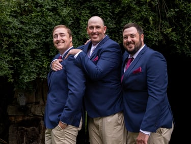 Groom and groomsmen standing laughing at camera, captured by Canberra wedding photographer