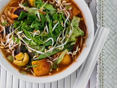 a bowl of soup with vegetables and noodles