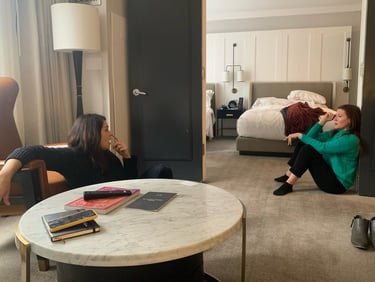 Image of two women talking seriously in a hotel room.