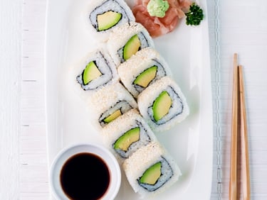 a plate of sushi rolls and chopsticks