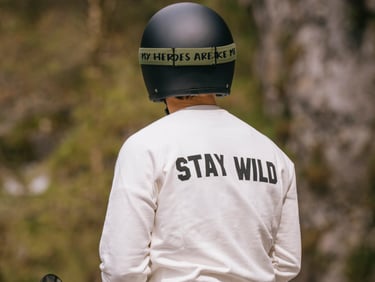Motocyklista w czarnym kalsycznym kasku, goglach i bluzie STAY WILD
