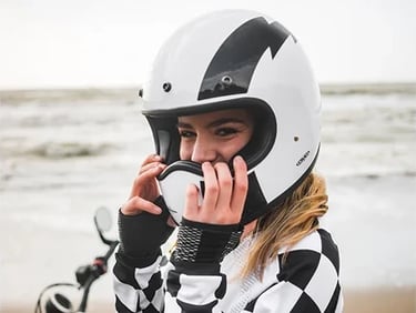 Piękna motocyklistka na plaży w kasku DMD Racer Flash