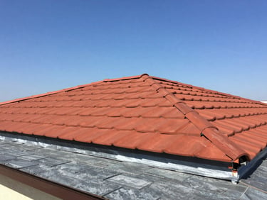 A fully restored modern tile roof in Manisa, pristine red clay tiles, professional membrane insulation underneath, clear blue sky, bright natural daylight