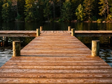 Close-up of a sturdy wooden dock extending into a Muskoka lake, showing precise decking and strong pilings, warm golden hour light, rich copper tones, shallow depth of field, 35mm film style