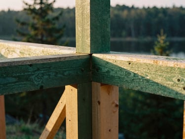Tight macro shot of heavy timber framing connection, showing precise, strong joinery, warm golden hour light, rich forest green tones, shallow depth of field, 35mm film style