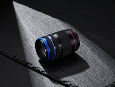 High-contrast studio shot of physical brand mockups on a dark slate table, sharp geometric shadows, cool-toned charcoal and electric blue accents, 35mm lens