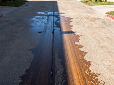 Dramatic before-and-after split of a pressure-washed driveway, half grime, half clean, bright Texas sunlight, sharp commercial photography.