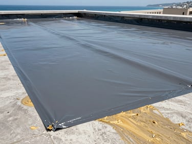 Close-up of professional waterproofing application on a flat concrete roof, thick protective grey membrane, neat edges