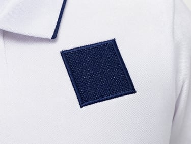 Macro close-up of a dense navy blue embroidery stitch on a white polo shirt, high fidelity, bright studio lighting
