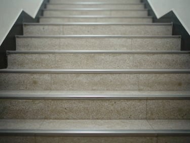 Top-down close-up of a freshly mopped staircase in a commercial building, grout lines clean, neutral artificial light, no footprints on the surface