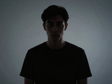 Editorial portrait of a subject with deep shadows, high contrast, sharp medium-format lens, cinematic film photography style, off-center composition with generous negative space, cool grays.
