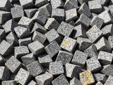 Close-up of clean, angular 20mm granite aggregates, sharp facets, high-contrast natural light showing raw texture