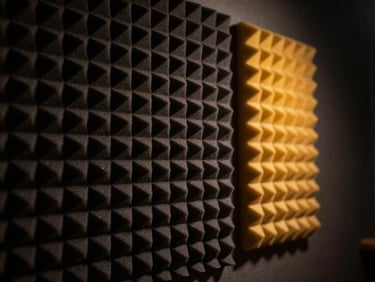 Moody cinematic photography of acoustic foam panels in a soundproof studio, dramatic side lighting casting deep shadows, dark charcoal tones, 50mm