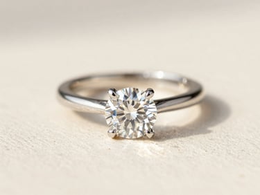 Macro shot of a brilliant diamond wedding band catching sharp light, clean ivory background, editorial fashion photography, 35mm