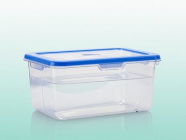 Clear plastic water chamber for medical humidifier, clean clinical background with soft teal reflection.