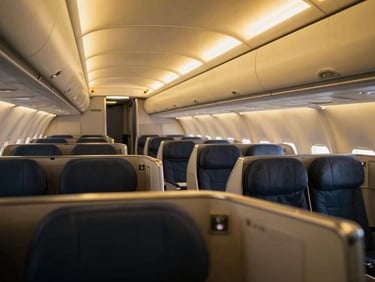 Empty premium first-class commercial flight cabin, modern sleek design, golden ambient lighting, luxury travel editorial