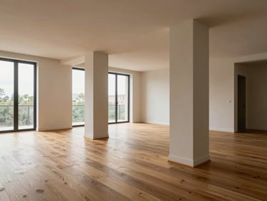 Architectural interior of a high-end apartment, natural oak wood flooring, clean structural columns, soft daylight illuminating the open space.