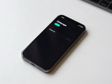 Overhead flat-lay of a smartphone on a near-white desk, screen lit showing a transaction clearance push notification with a teal status indicator, high-key studio lighting, tight crop, no hands, no background clutter