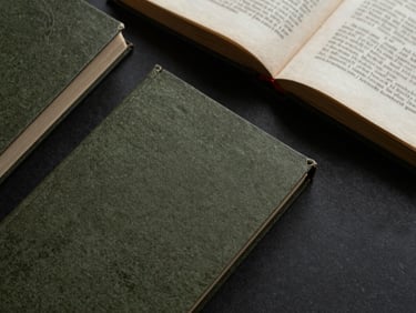 Overhead flat lay of a vintage manuscript, open books, tactile paper textures, moody shadows, soft diffused daylight, deep olive and black tones, macro lens, 35mm