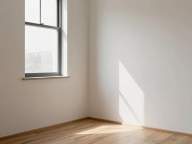 Sunlit bedroom corner with a simple window, natural light casting soft shadows on off-white walls, bare wood floor, calm and unadorned