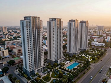 Wide-angle drone perspective of modern luxury residential towers along Dwarka Expressway Gurugram, showcasing landscaped gardens and a swimming pool under golden hour light.