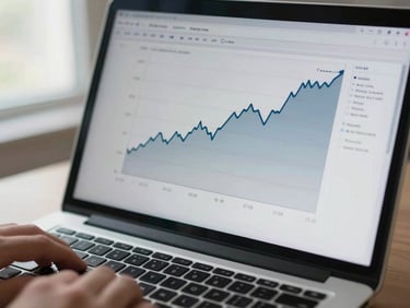Close overhead view of a laptop screen displaying a soft upward-trending line graph with multiple data layers in muted blues and grays, clinical notes visible alongside the chart, a hand resting near the keyboard, natural window light from the left, shallow depth of field on the screen surface