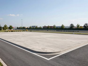 Clean commercial land plot next to a modern highway, bright natural daylight, 35mm
