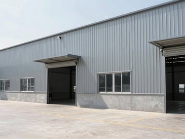 Exterior of a modern clean industrial warehouse with grey steel panels, bright daylight, sharp focus, 35mm